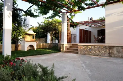 a patio with a stone wall and a pergola at Anna 's House - Garden Cottage in Kissamos in Kissamos