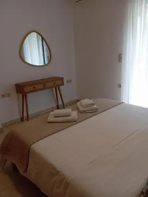 a bedroom with a bed with a mirror and towels at Villa Christina Anidri in Ánidhroi