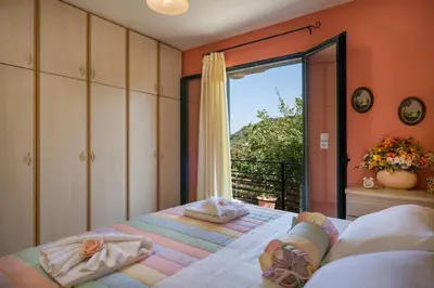 a bedroom with two beds and a balcony at Villa La Palma in Vrísai