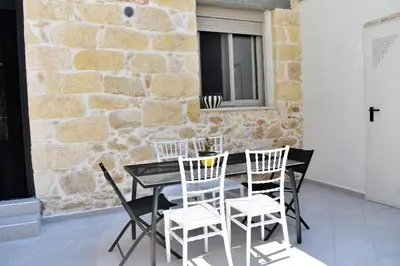 a black table and chairs in front of a stone wall at The Well in Chania Town