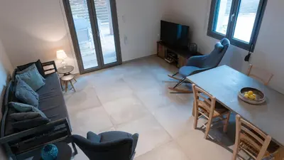 a living room with a couch and a table and chairs at Arhondiko Luxury House in Sougia