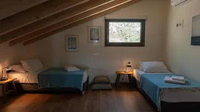 a room with two beds and a window at Arhondiko Luxury House in Sougia