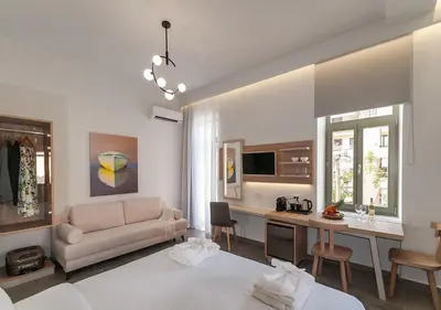 a white living room with a couch and a desk at Epavli Boutique Hotel in Chania Town