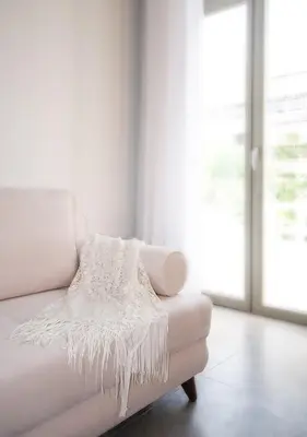 a white couch in a white room with a window at Epavli Boutique Hotel in Chania Town
