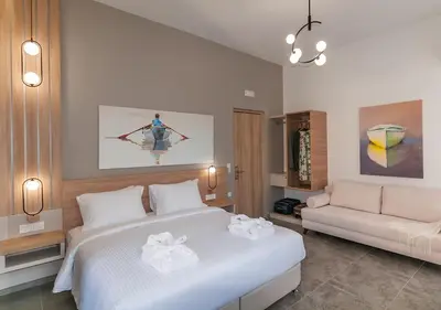 a bedroom with a large white bed and a couch at Epavli Boutique Hotel in Chania Town