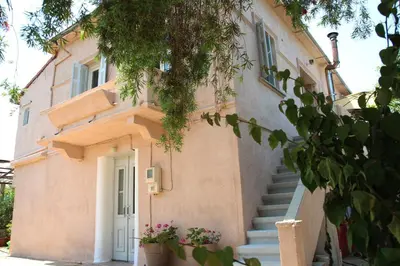 a building with stairs leading up to a door at house in the village near the sea in Maleme