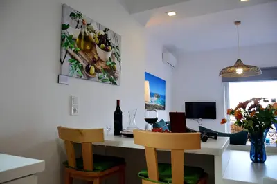 a kitchen with two chairs and a table with a wine glass at Villa Patroklos in Daratso