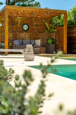 a patio with a couch and a clock above a pool at Chania Elite Homes, Enjoy a Chic Oasis by the heated Pool in Kounoupidhianá