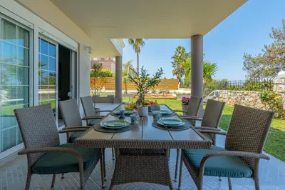 a wooden table and chairs on a patio at Chania Elite Homes, Enjoy a Chic Oasis by the heated Pool in Kounoupidhianá
