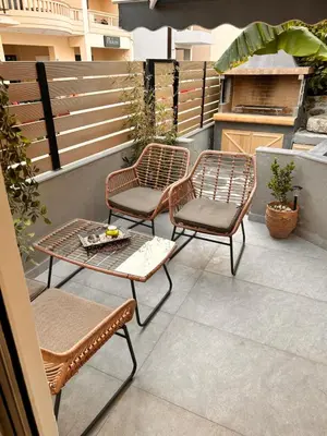 a patio with three chairs and a table and a grill at Evis House in Chania Town