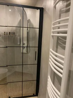a glass shower in a bathroom with white towels at Evis House in Chania Town