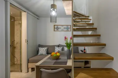 a living room with a table and a couch and stairs at Penny's Old Town Houses in Chania Town