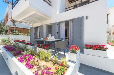 a balcony with a table and flowers on a building at Rotunda Suites in Kalamaki Chanion