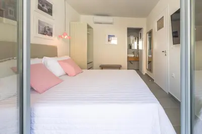 a bedroom with a large white bed with pink pillows at Rotunda Suites in Kalamaki Chanion