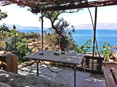 a picnic table with a view of the ocean at apartment over the sea Private place to swim in Ravdhoúkha