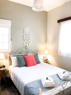 a bedroom with a bed with red and blue pillows at Elia's House Traditional & Cozy by 8essentially in Kalyves