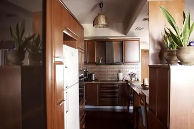 a kitchen with wooden cabinets and a white refrigerator at Double View Apartment in Agia Marina Nea Kydonias