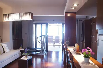 a living room with a couch and a table with flowers at Double View Apartment in Agia Marina Nea Kydonias