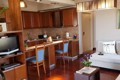 a kitchen and living room with a couch and a television at Double View Apartment in Agia Marina Nea Kydonias