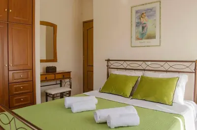 a bedroom with a bed with two green pillows at Villa Aretaki in Kalamaki Chanion