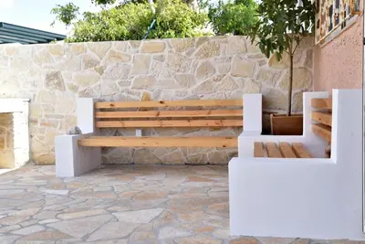 a wooden bench sitting next to a stone wall at House near Balos in Kissamos in Kissamos