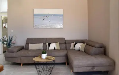 a living room with a brown couch and a table at House near Balos in Kissamos in Kissamos