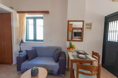 a living room with a blue couch and a table at Camara Studios in Chania Town