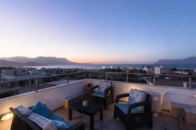 a balcony with chairs and tables and a view of the city at Anastellar in Kissamos