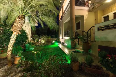 a garden with a palm tree and green lights at Anastellar in Kissamos
