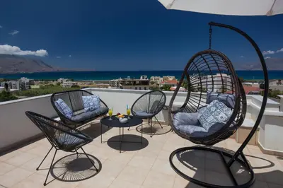 a patio with three chairs and a table on a balcony at Anastellar in Kissamos