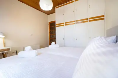 two beds in a bedroom with white walls at Metropolis House in Chania Town