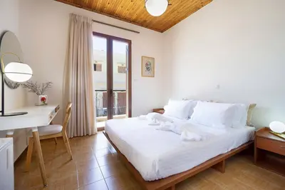 a bedroom with a white bed and a desk and a window at Metropolis House in Chania Town