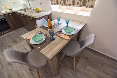 a wooden table with chairs and plates and wine glasses at Pasiphae New Apartment sea & city in Chania Town