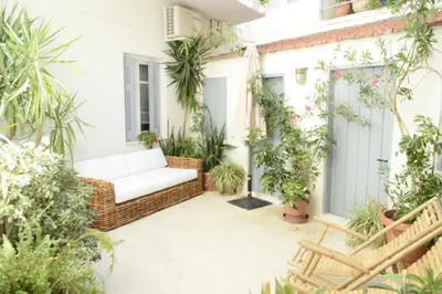an outdoor patio with a wicker couch and plants at Casa Armada in Chania Town