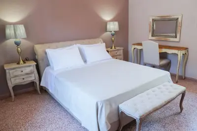 a bedroom with a large white bed and a chair at Casa Armada in Chania Town