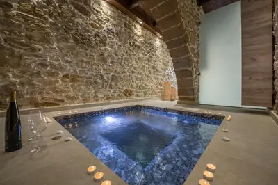 a hot tub in a room with a stone wall at Doro Villas in Kissamos