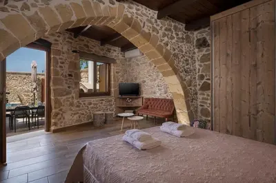 a bedroom with a bed in a stone wall at Doro Villas in Kissamos