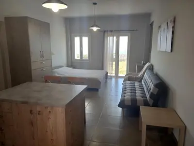 a living room with a bed and a couch at Cozy secluded studio with panoramic view in Áyios Yeóryios