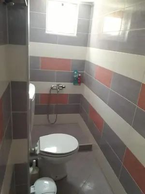 a small bathroom with a toilet and a window at Cozy secluded studio with panoramic view in Áyios Yeóryios