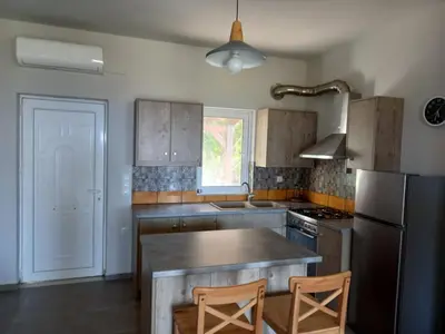 a kitchen with a counter top and a refrigerator at Cozy secluded studio with panoramic view in Áyios Yeóryios