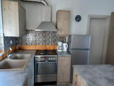 a kitchen with a stove and a sink and a refrigerator at Cozy secluded studio with panoramic view in Áyios Yeóryios