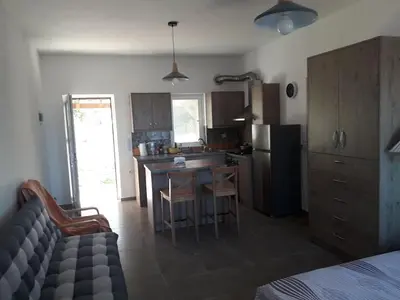 a kitchen with a table and a kitchen with a refrigerator at Cozy secluded studio with panoramic view in Áyios Yeóryios