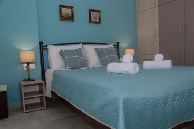 a blue bedroom with a bed with towels on it at Tonia's Apartment in Kissamos
