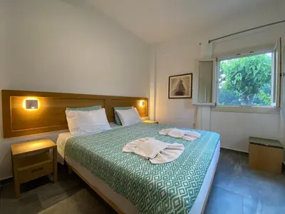 a bedroom with a bed with two towels on it at Chrisi Holiday Home - 500 sqm Private Gardens & Nature View - 300m by the sea in Almirida