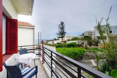 a balcony with two chairs and a table on it at House on the sea near Chania in Galatás