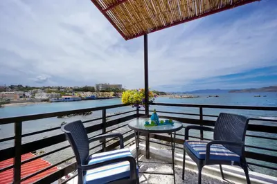 a table and chairs on a balcony with a view of the water at House on the sea near Chania in Galatás