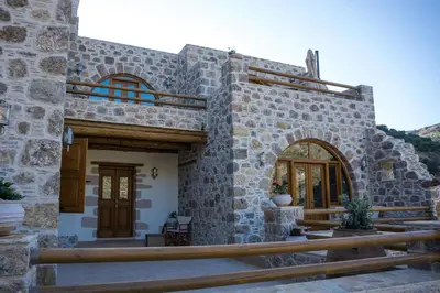 a stone house with a wooden door and a porch at To Spiti mas in Sougia