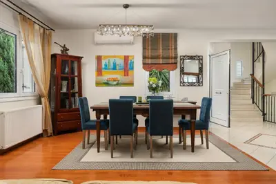 a dining room with a table and blue chairs at Cedar Tree Villa in Kounoupidhianá