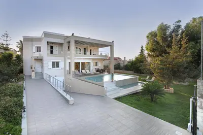 a large white house with a swimming pool on a patio at Cedar Tree Villa in Kounoupidhianá
