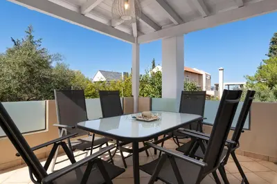 a dining table and chairs on a patio at Cedar Tree Villa in Kounoupidhianá